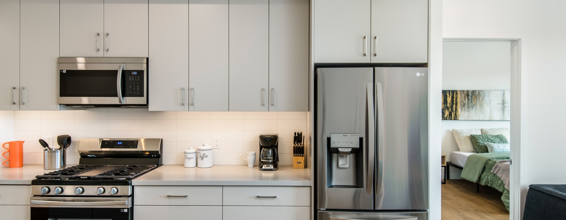 A large kitchen with white cabinets and stainless steel appliances