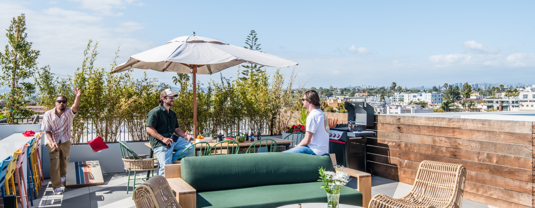 Residents enjoying the rooftop lounge and playing games on a beautiful sunny day